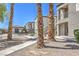 Exterior shot of condos with landscaping, palm trees, and a glimpse of the community pool at 6160 Rumrill St # 215, Las Vegas, NV 89113