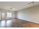 Sunlit living area with wood-look flooring, modern lighting, and a sliding glass door to the outside at 6160 Rumrill St # 215, Las Vegas, NV 89113