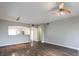 Spacious living room featuring wood-look floors, modern lighting, and a view into the updated kitchen at 6160 Rumrill St # 215, Las Vegas, NV 89113