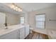 Bright bathroom featuring double sink vanity, marble countertops, and wood-look flooring at 6264 Canebrake Ct, Las Vegas, NV 89141