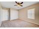 Neutral bedroom featuring a ceiling fan, closet, window with blinds, and neutral carpeting at 6264 Canebrake Ct, Las Vegas, NV 89141