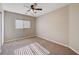Neutral bedroom featuring a ceiling fan, window with blinds, and neutral carpeting at 6264 Canebrake Ct, Las Vegas, NV 89141