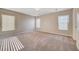 Large carpeted bedroom featuring neutral paint and ample natural light from three windows at 6264 Canebrake Ct, Las Vegas, NV 89141