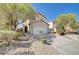 Two story home featuring a two-car garage and low maintenance desert landscaping at 6264 Canebrake Ct, Las Vegas, NV 89141