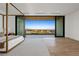 Spacious bedroom with floor to ceiling sliding doors, modern four-poster bed and mountain views at 68 Sun Glow Ln, Las Vegas, NV 89135