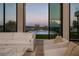 Bright living room featuring white sofas and a view of the pool with water features at dusk at 68 Sun Glow Ln, Las Vegas, NV 89135