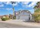 Charming two-story home featuring a two-car garage, desert landscaping, and mature palm trees at 6909 Fruit Flower Ave, Las Vegas, NV 89130