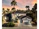 Charming two-story home featuring a two-car garage, desert landscaping, and mature palm trees during sunset at 6909 Fruit Flower Ave, Las Vegas, NV 89130