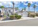 Charming two-story home featuring a two-car garage, desert landscaping, and mature palm trees at 6909 Fruit Flower Ave, Las Vegas, NV 89130