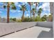 A spacious patio area surrounded by palm trees and a low stucco wall, perfect for relaxing and enjoying the outdoors at 6909 Fruit Flower Ave, Las Vegas, NV 89130