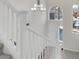 Well-lit staircase with white banister leading to a landing with large windows and a modern chandelier at 6909 Fruit Flower Ave, Las Vegas, NV 89130