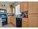 Practical kitchen with black appliances, tile floors and wooden cabinets at 6916 Gothic Marigold St, Las Vegas, NV 89149