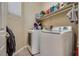 Functional laundry area with modern washer and dryer, and shelving at 6916 Gothic Marigold St, Las Vegas, NV 89149