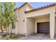 A close-up of a well-maintained home exterior featuring a covered garage and desert landscaping at 7472 Garnet Moon St, North Las Vegas, NV 89084