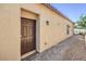 Close-up of the front door with a welcome mat, set against a backdrop of gravel and a pathway at 7472 Garnet Moon St, North Las Vegas, NV 89084