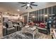 Open-concept living room flowing into a modern kitchen, featuring stylish furniture and a ceiling fan at 7472 Garnet Moon St, North Las Vegas, NV 89084