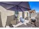 Cozy outdoor patio featuring a dining table, umbrella, grill, and comfortable seating, perfect for relaxing or entertaining at 7472 Garnet Moon St, North Las Vegas, NV 89084