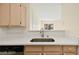 Bright kitchen with steel sink and view to patio, featuring white countertops and light wood cabinets at 7885 W Flamingo Rd # 1131, Las Vegas, NV 89147