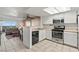 Well-lit kitchen features white cabinets and stainless steel appliances overlooking the living area at 8070 W Russell Rd # 1023, Las Vegas, NV 89113