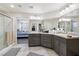 Bathroom featuring double vanity, shower, and access to the main bedroom at 9238 Bluemist Falls St, Las Vegas, NV 89123