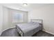 Simple bedroom features neutral walls, a metal frame bed, gray carpet, and natural light at 9238 Bluemist Falls St, Las Vegas, NV 89123