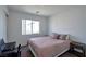Well-lit bedroom with a comfortable bed, desk, and side tables at 9443 Hot Breeze St, Las Vegas, NV 89178