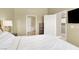 A bedroom features neutral walls, a white bed, and a view into an ensuite at 9975 Peace Way # 2009, Las Vegas, NV 89147