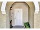 Close-up of the inviting front door with charming details and potted plants at 9975 Peace Way # 2009, Las Vegas, NV 89147