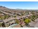 This captivating aerial shot shows a neighborhood with backyard pools and manicured landscaping, surrounded by a desert landscape at 12269 Catanzaro Ave, Las Vegas, NV 89138