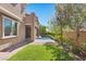 View of the green backyard featuring a well-manicured lawn, lush landscaping, and access to the pool area at 12269 Catanzaro Ave, Las Vegas, NV 89138