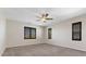 Spacious bedroom featuring carpet floors, neutral walls, window shutters and a ceiling fan at 12269 Catanzaro Ave, Las Vegas, NV 89138