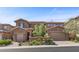 Charming two-story home featuring a well-maintained landscape, brick accents, and attached garages at 12269 Catanzaro Ave, Las Vegas, NV 89138