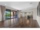 Open concept living room with wood floors and views into the kitchen and backyard at 12269 Catanzaro Ave, Las Vegas, NV 89138