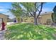 A large backyard features a lush green lawn with a mature shade tree at 1331 Melville Dr, Las Vegas, NV 89102