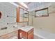 A clean vintage bathroom has a tub, toilet, and cabinet sink with accessories at 1331 Melville Dr, Las Vegas, NV 89102