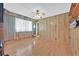 Bright living room with hardwood floors, wood-paneled walls, and a vintage ceiling fan at 1331 Melville Dr, Las Vegas, NV 89102