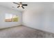 Bedroom with neutral carpeting, a ceiling fan, and a view from the window at 1403 Graystone Canyon Ave, Las Vegas, NV 89183