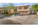 Two-story home with a neutral color palette, balcony, three-car garage, and a well-manicured lawn at 1403 Graystone Canyon Ave, Las Vegas, NV 89183