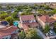 Aerial view showcases a home's tile roof, driveway, and backyard pool in a verdant neighborhood at 1513 Ravanusa Dr, Henderson, NV 89052