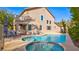 Backyard features a sparkling pool, jacuzzi, covered patio, and a comfortable seating area at 1513 Ravanusa Dr, Henderson, NV 89052
