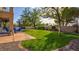 Backyard featuring a patio with furniture, a grassy lawn, mature trees, and decorative border at 1513 Ravanusa Dr, Henderson, NV 89052