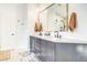 Modern bathroom featuring a double vanity, modern fixtures, large mirror and decorative towels at 1513 Ravanusa Dr, Henderson, NV 89052
