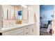 Bright bathroom featuring a double vanity with gold hardware and a view into an adjacent room at 1513 Ravanusa Dr, Henderson, NV 89052
