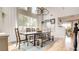Bright dining room with a rustic wood table, bench seating, chandelier, and large windows providing natural light at 1513 Ravanusa Dr, Henderson, NV 89052