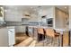 Modern kitchen features white cabinets, a granite island with seating, stainless steel appliances, and hardwood floors at 1513 Ravanusa Dr, Henderson, NV 89052