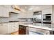 Stylish kitchen with granite countertops, white cabinets, stainless steel appliances, and a subway tile backsplash at 1513 Ravanusa Dr, Henderson, NV 89052