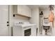 A laundry room with a washer and dryer, utility sink, and overhead cabinets at 1513 Ravanusa Dr, Henderson, NV 89052