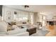 Bright living room with a comfortable sectional sofa, stylish accents, and open access to kitchen and dining area at 1513 Ravanusa Dr, Henderson, NV 89052