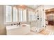 This bathroom includes a soaking tub, a glass shower, and a window for natural lighting at 1513 Ravanusa Dr, Henderson, NV 89052
