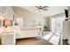 Well-lit main bedroom featuring neutral colors, carpet floors, ceiling fan and access to outdoor balcony at 1513 Ravanusa Dr, Henderson, NV 89052